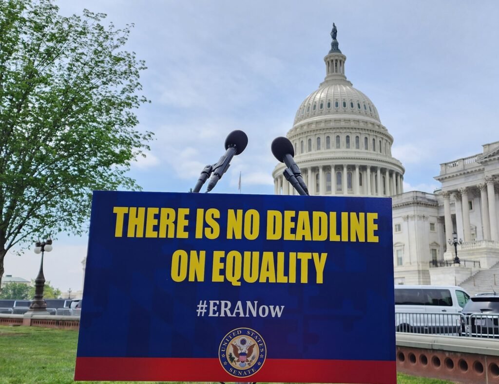Podium with sign that reads" there is no deadline on equality", with Capitol Hill in the background